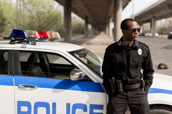 The back of a uniform Police Officer by a Police vehicle on the