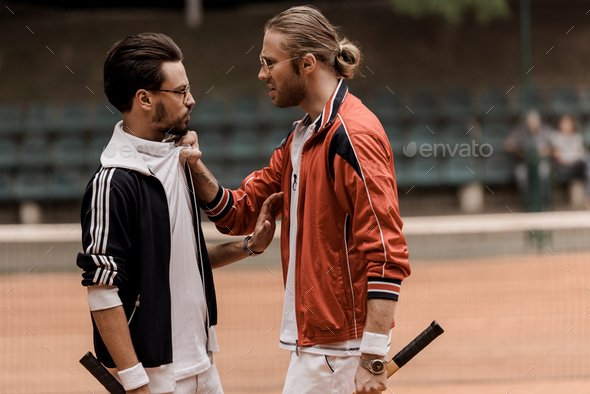 side view of retro styled tennis players having conflict at tennis court