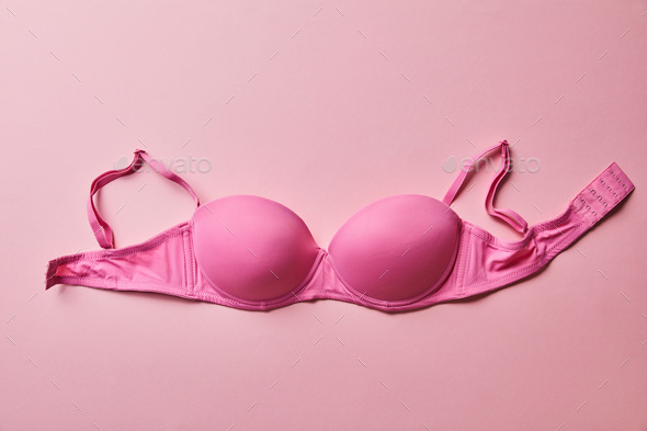top view of pink brassiere on light pink background, breast cancer concept  Stock Photo by LightFieldStudios