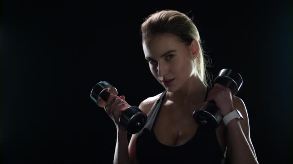 Fitness Woman Training Dumbbell Exercise on Black Background. Sport Model alt