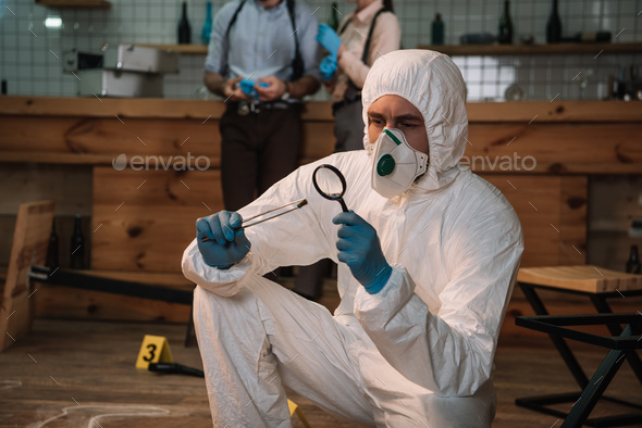 Focused Forensic Investigator Examining Evidence With Magnifying Glass ...