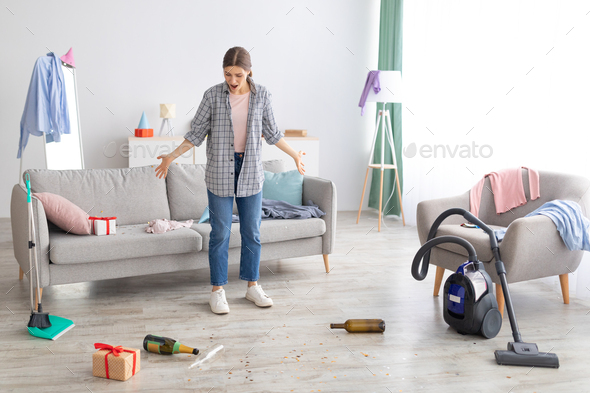Young woman standing in messy apartment after party, screaming from despair, empty space