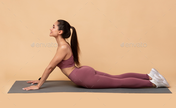 Woman practicing yoga performing yoga-asanas. Young attractive