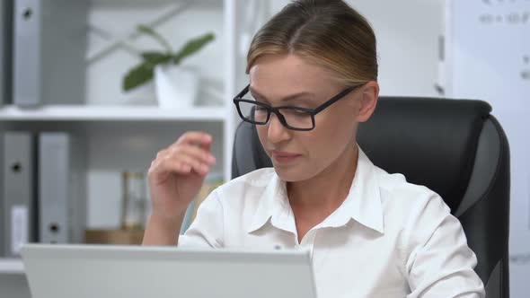 Tired Female Manager Working in Office Taking Off Eyeglasses and Massaging Nose