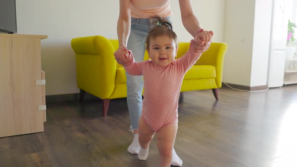 Cute Smiling Nice Baby Girl Learning to Walk in the Living Room alt