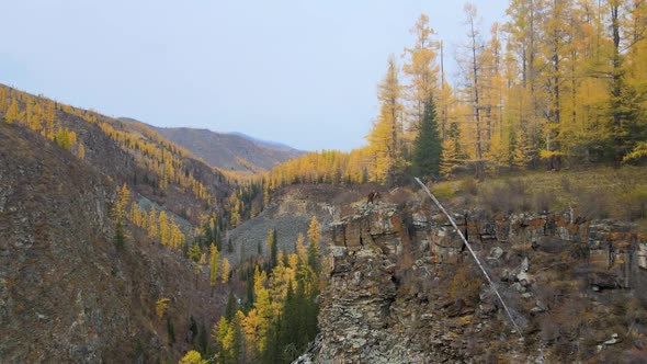 Flight Along a Beautiful Cliff of a Rocky Gorge Two Tourists Stand on the Edge of the Cliff and Look