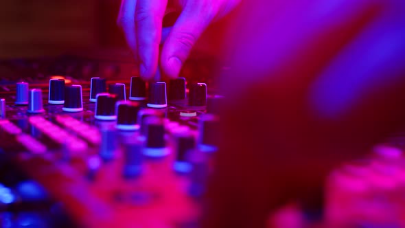 Sound Engineer Works at Mixer in Neon Light Closeup alt