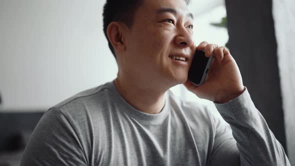 Asian positive man talking by phone alt