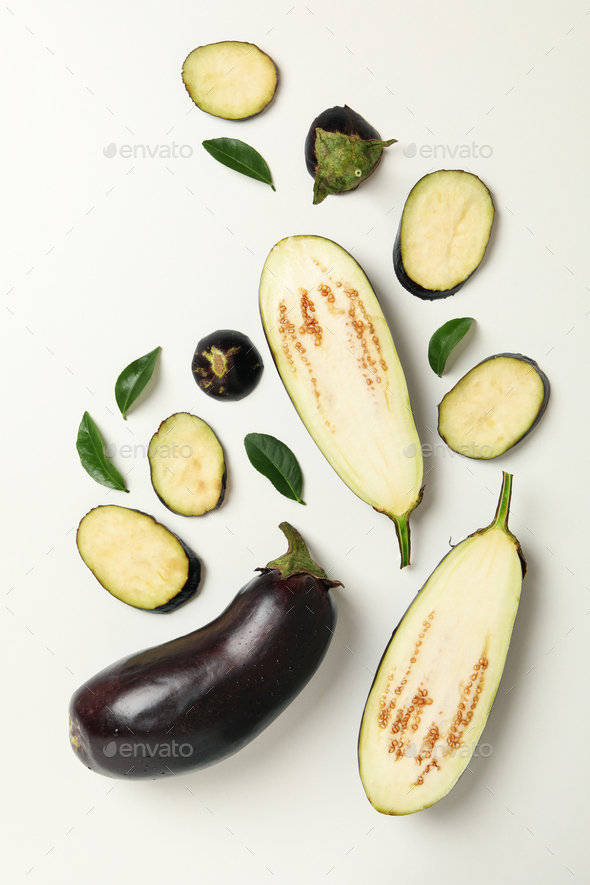 Chopped eggplants and leaves on white background Stock Photo by