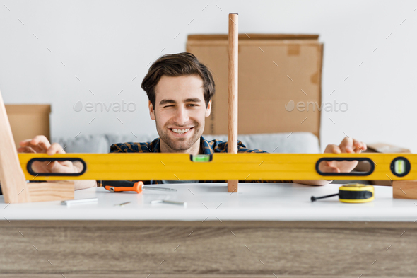 Cheerful handyman working at home, repairing, assembling and renovation or new hobby