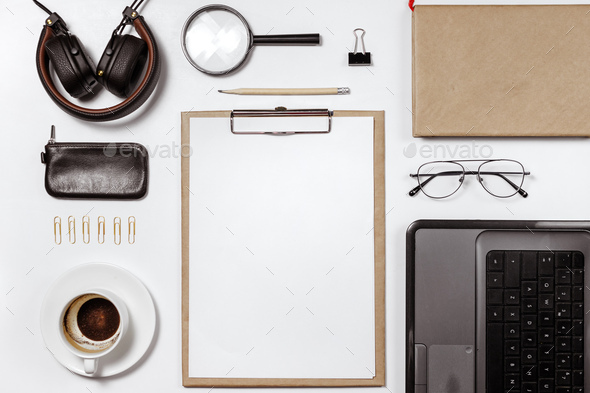 Flat lay of stylish male workplace with clip folder, laptop and