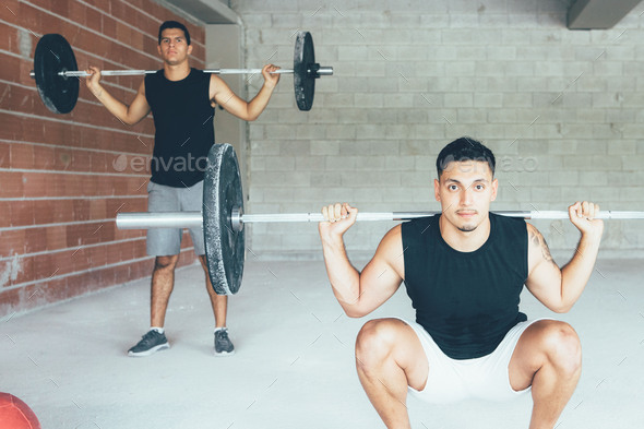 Couple_of_fit_men_doing_squats_exercises_with_barbell - Stock Photo - Images