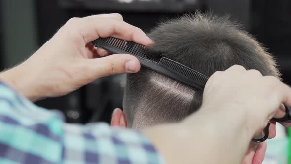 Cropped Shot of a Professional Barber Cutting Hair of a Man
