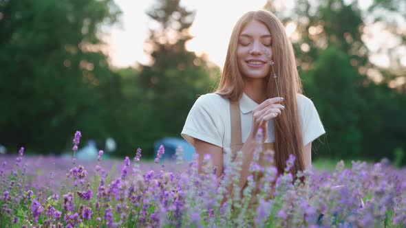 Smiling Woman Smelling Flower in Lavender Field alt