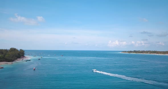 Speedboat travelling through tropical blue island water, aerial view