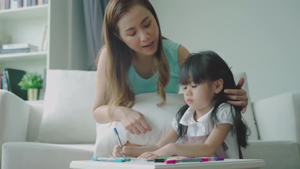 An Asian Mother Teaching Her Daughter at Home 10 alt