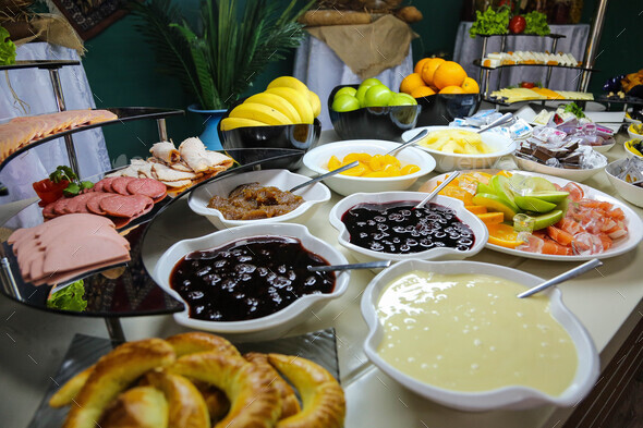 breakfast buffet sausages ham fruits vegetables jams side view