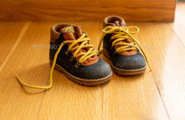 Baby shoes on wood, closeup view, child booties blue and yellow color