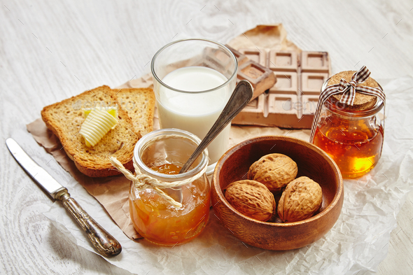 Side View Of Breakfast Set With Jam Bread Butter Walnuts And Milk Stock Photo By Bublikhaus