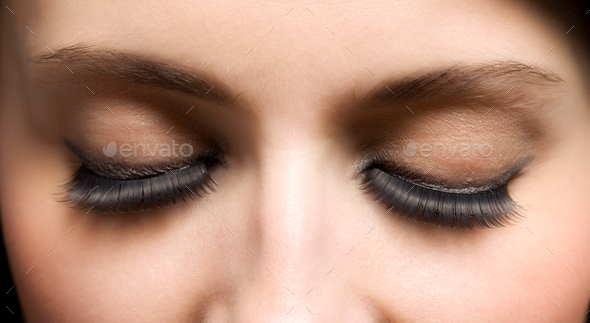 Closed eyes of young womans face with extended lashes
