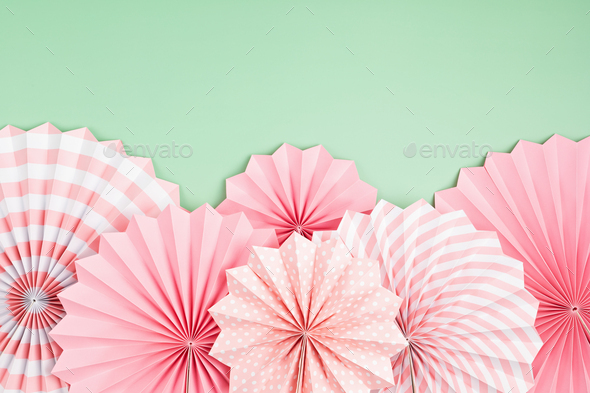 Festive party background with pink paper circle fans over pastel background.  Festival, birthday Stock Photo by OksaLy