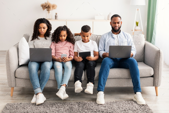 African american family holding and using gadgets