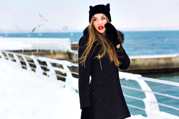 Fashion winter portrait of elegant blonde lady woman, enjoy cold snow time at the sea