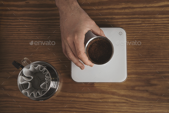 Barista pours ground coffee to aeropress Stock Photo by bublikhaus