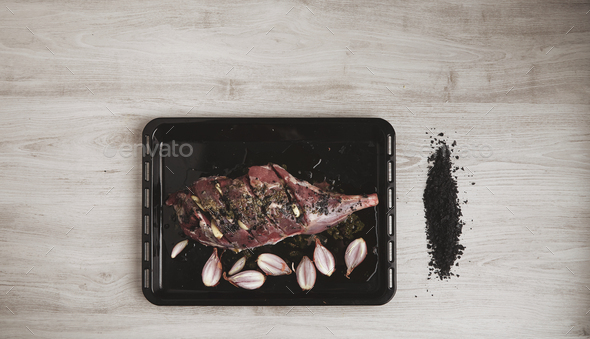 Pre cooked lamb leg on black roasting plate top view - Stock Photo - Images
