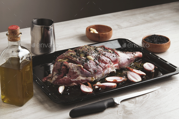 Pre cooked lamb leg on black roasting plate - Stock Photo - Images