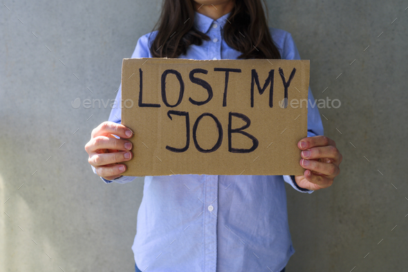 Woman in blue shirt with cardboard sign LOST JOB