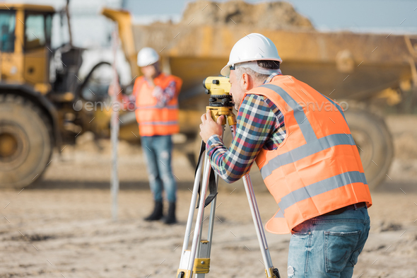 Two road construction workers using measuring device on the field Stock ...