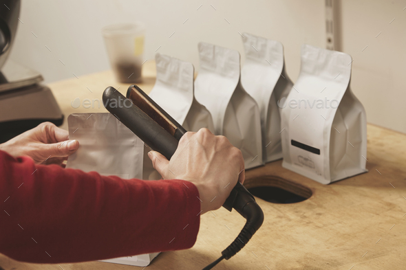 Woman hand seal blank packages for retail sale - Stock Photo - Images
