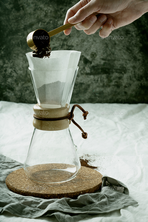 Preparing pour over,  filtered coffee with dripper, putting ground coffe in the filter. - Stock Photo - Images