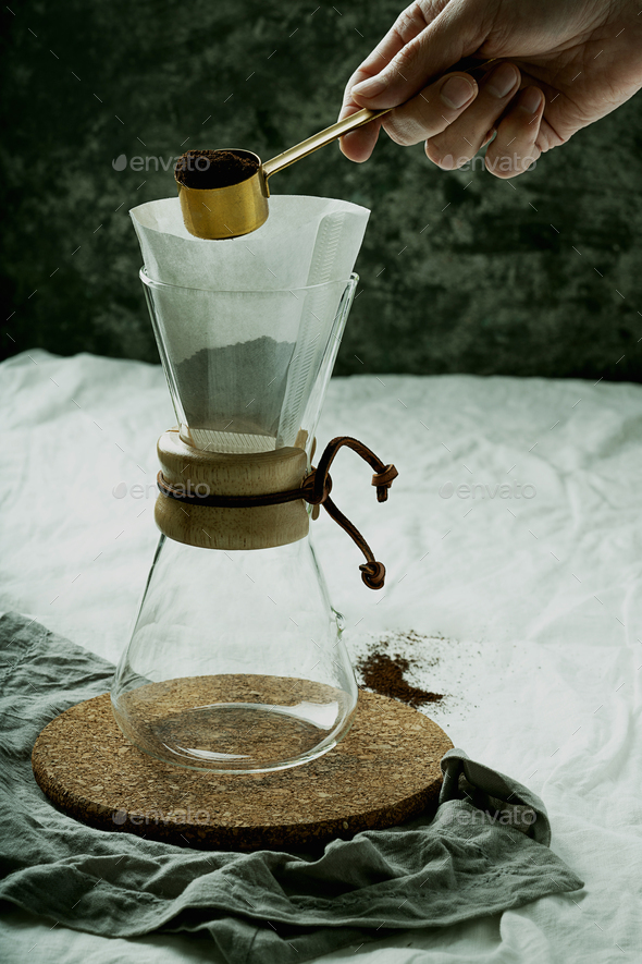 Preparing pour over,  filtered coffee with dripper, putting ground coffe in the filter. - Stock Photo - Images