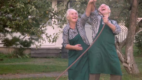 Elderly Couple with Garden Hose alt