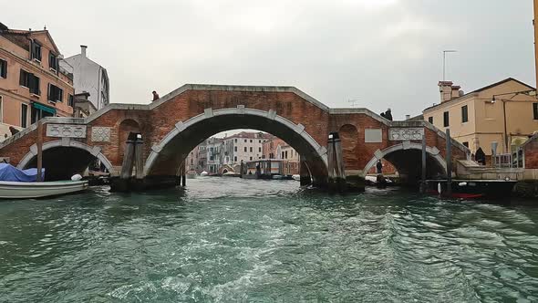 Ponte dei Tre Archi bridge in Cannaregio seen from sailing boat on canal, Venice in Italy. Slow moti alt