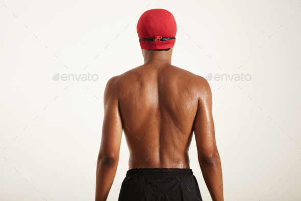 Back of a strong black swimmer in cap and goggles