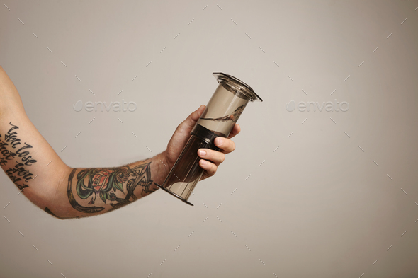 Barista pours ground coffee to aeropress Stock Photo by bublikhaus