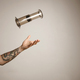 Tattoed man&#39;s arm throwing and catching aeropress - PhotoDune Item for Sale