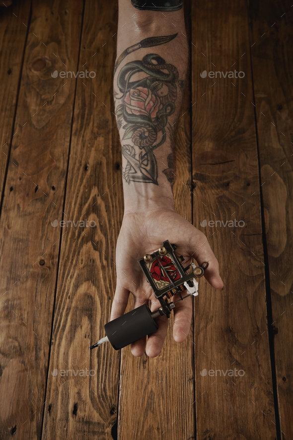 Close up of a man's hand with tattoo gun