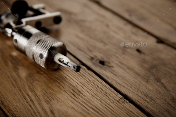 Tattoo gun on a rustic wooden table