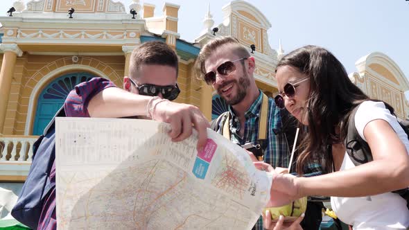 Group of tourist friends looking for direction at the map