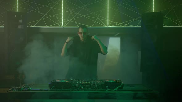 Young DJ Dancing Touching Vinyl Plate Sliders and Buttons of Mixer Controller alt