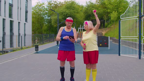 Senior Man Grandfather Coach Teaching Grandmother with Sport Weightlifting Fitness Cardio Exercises alt