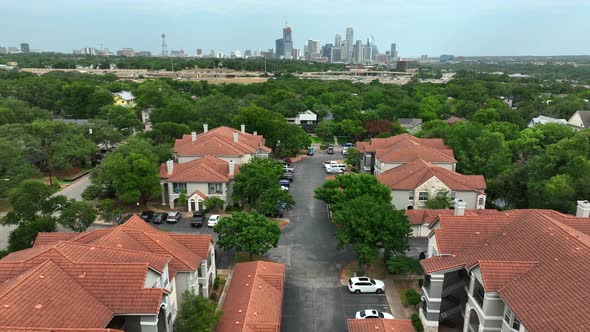 Large private gated homes and apartment community in USA. Urban city skyline in distance. Aerial pul alt