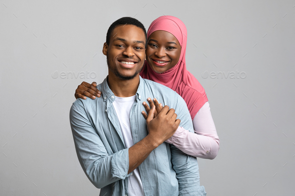 Couple posing in studio, him sitting on a chair while she stand Stock Photo  by ©feedough 96922696