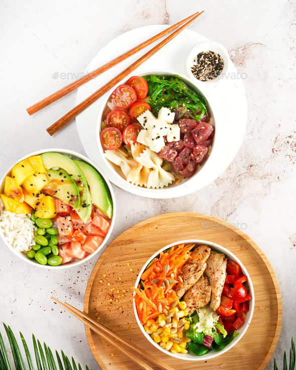 Asian trendy poke bowls with salmon, tuna, heura soy protein vegan chicken, variety vegetables.
