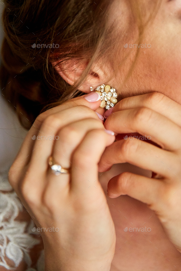 Wedding earrings on a female hand, she takes the earrings, the bride fees - Stock Photo - Images