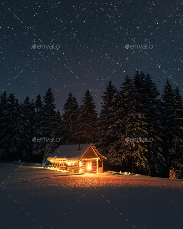 Fantastic winter landscape with wooden house in snowy mountains